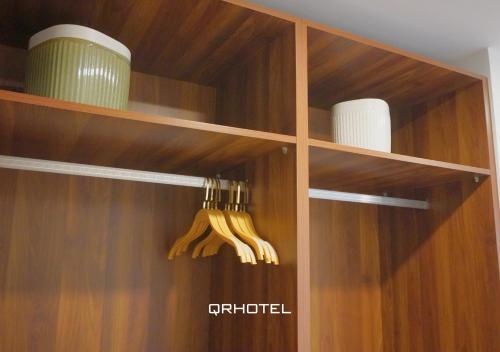 a closet with wooden shelves with plates and utensils at QR Hotel Dalat in Xuan An