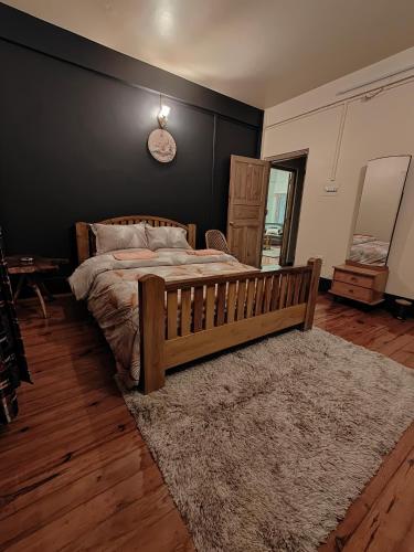 a bedroom with a wooden bed and a clock on the wall at Ïa-Ki Homestay in Shillong