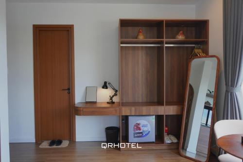 a room with a mirror and a wooden shelf at QR Hotel Dalat in Xuan An