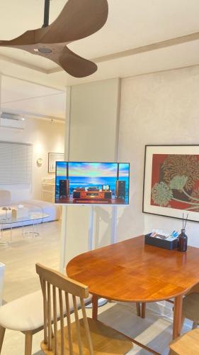 a dining room with a table and a tv on the wall at Villa de EL 1 in Busan