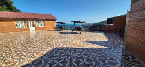 a patio with a tile floor on a building at Goga Guest House in Kvariati