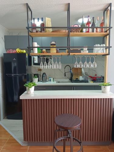 a kitchen with a counter with a stool and a table at habitacion privada en departamento compartido in Santiago