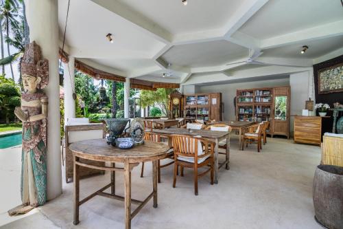 a dining room with wooden tables and chairs at The Village of Angels in Manggis