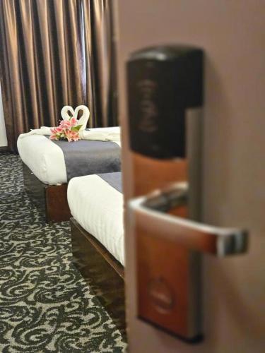 two beds in a hotel room with sidx sidx sidx sidx at Go Lodge Hotel Kuantan in Kuantan