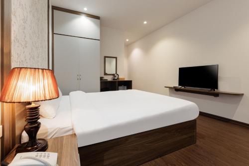 a bedroom with a large white bed and a television at Dancenter Near West Lake Hanoi, Truc Bach Lake Formerly Le Grand The Central Park in Hanoi