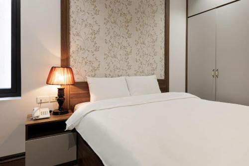 a bedroom with a bed and a lamp and a telephone at Dancenter Near West Lake Hanoi, Truc Bach Lake Formerly Le Grand The Central Park in Hanoi