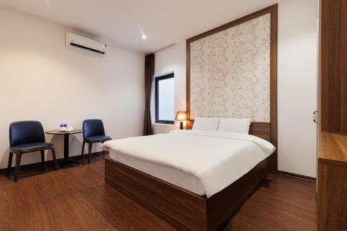 a bedroom with a bed and two chairs and a table at Dancenter Near West Lake Hanoi, Truc Bach Lake Formerly Le Grand The Central Park in Hanoi