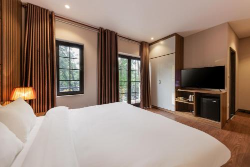 a bedroom with a large white bed and a flat screen tv at Dancenter Near West Lake Hanoi, Truc Bach Lake Formerly Le Grand The Central Park in Hanoi