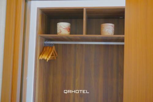 a wooden cabinet with knick knacks in it at QR Hotel Dalat in Xuan An