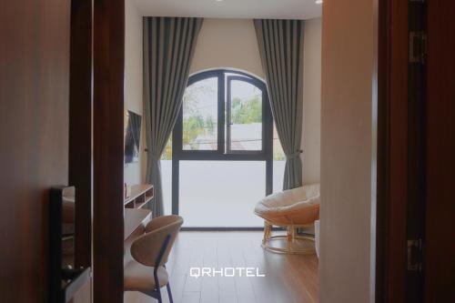 a room with a window and a table and chairs at QR Hotel Dalat in Xuan An