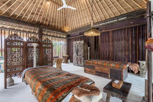 a bedroom with a bed and a wooden wall at The Village of Angels in Manggis