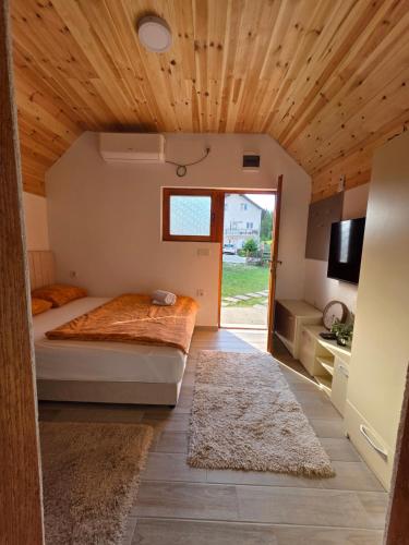 a bedroom with a bed and a wooden ceiling at Sweet Place in Žabljak