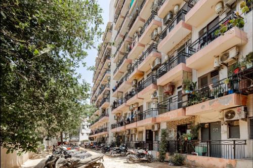 a street with motorcycles parked in front of tall buildings at Super Luxury Independent Studio in Gurgaon