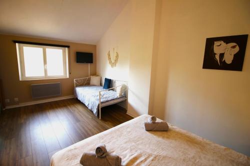 a bedroom with two beds and a window at - Ancien Chai 6 pers - Vignobles - Nature - Piscine - Les hauts de la Rameyo - in Gaillac