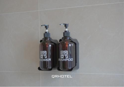 two bottles of soap are sitting on a wall at QR Hotel Dalat in Xuan An