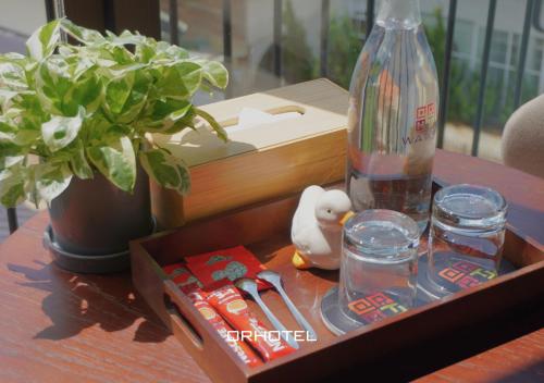 a wooden tray with a bottle and glasses on a table at QR Hotel Dalat in Xuan An