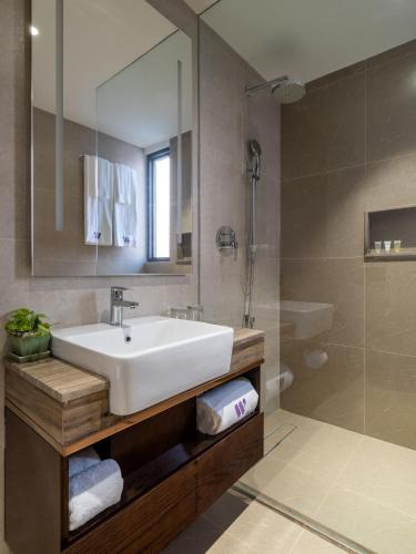 a bathroom with a white sink and a shower at W Residence Living in Dhaka