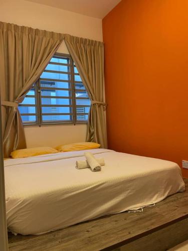 a bedroom with a large white bed with a window at The Cave in Tanah Rata