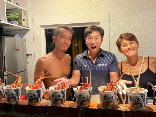 a group of three people standing around a table with food at Ubud Villa in Hengchun