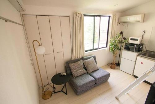 una pequeña sala de estar con sofá y ventana en SCS201, 20 mins to Skytree,30 mins to Ueno Ginza, en Tokio