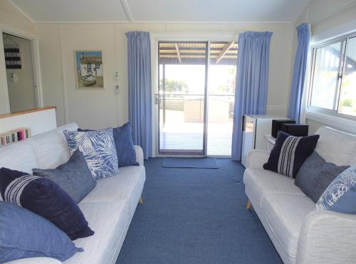 a living room with two couches and a sliding glass door at Serenity By The Sea in Port Hughes