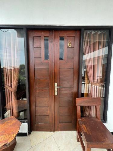 a wooden door in a room with two benches at Canggu 77 Guest House in Badung