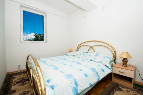 a white bedroom with a bed and a window at Apartment Polaris in Ohrid