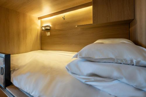 a bed with a wooden head board and pillows at 不负韶华青年旅馆 Youth Hostel in Suzhou