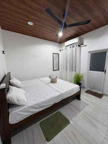 a bedroom with a large bed and a flat screen tv at Cealora Resort in Dambulla