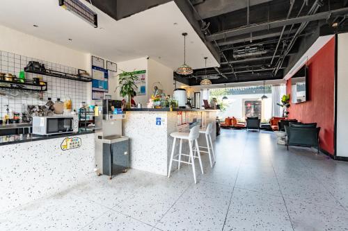 a kitchen with a counter and chairs in a room at 不负韶华青年旅馆 Youth Hostel in Suzhou