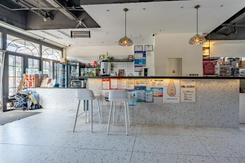 a coffee shop with two stools in a room at 不负韶华青年旅馆 Youth Hostel in Suzhou