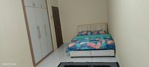 a small bedroom with a bed and a mirror at Alfian Homestay in Johor Bahru