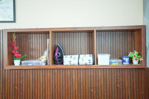 a wooden shelf with flowers and other items on it at Stella Marries Airpot Lounge in Nedumbassery