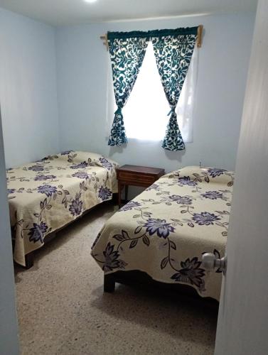 two beds in a room with a window at Departamento entero en Lomas de Sotelo cerca de Polanco in Mexico City