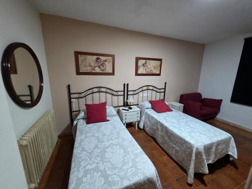 ein Schlafzimmer mit zwei Betten und einem Spiegel in der Unterkunft Río España - 5 habitaciones in San Miguel