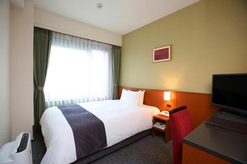 a hotel room with a bed and a television at Kyoto Garden Palace in Kyoto