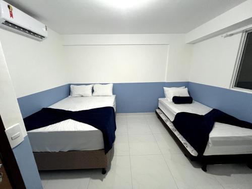 two beds in a room with blue and white walls at Summer Apartment in Porto De Galinhas