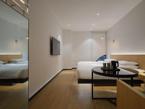 a hotel room with two beds and a table at SFEEL设计师酒店Designer Hotel成都太古里春熙路步行街店 in Chengdu