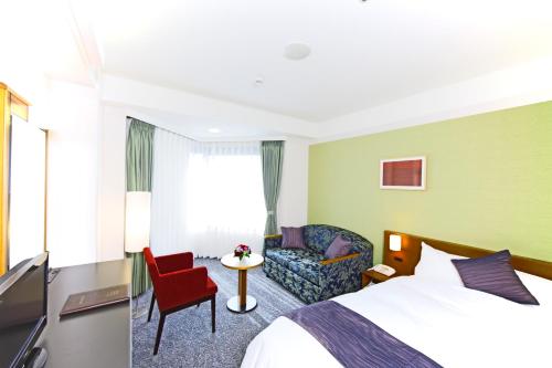 a hotel room with a bed and a chair at Kyoto Garden Palace in Kyoto