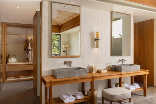 un bagno con due lavandini e uno specchio di Alaya Suites Ubud ad Ubud