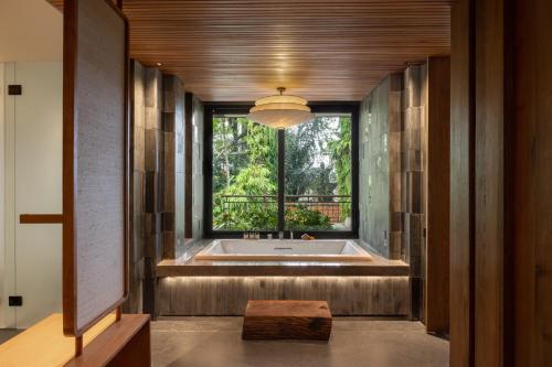 un ampio bagno con vasca e finestra di Alaya Suites Ubud ad Ubud
