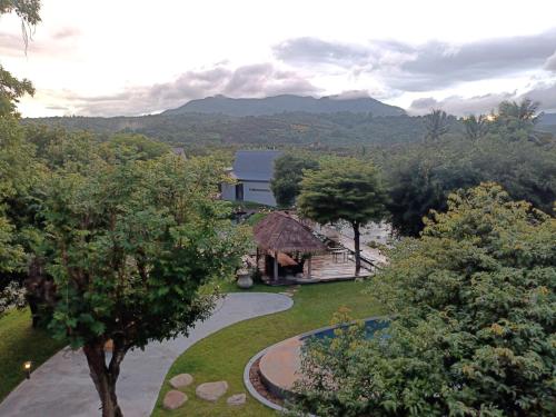 a view of a garden with a building and trees at Chombua MaeWang ชมบัว in Chiang Mai
