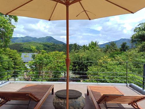 a patio with two tables and an umbrella at Chombua MaeWang ชมบัว in Chiang Mai