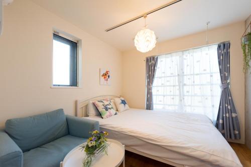 a bedroom with a bed and a couch and a window at Fare Metallo Tokyo Nakano 11-room Hotel in Tokyo