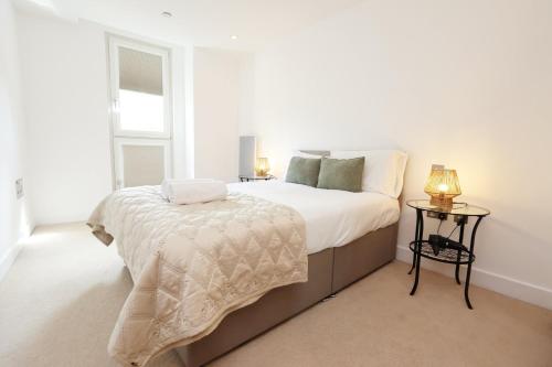 Un dormitorio blanco con una cama y una ventana. en Central Cardiff Stay Near Everything!, en Cardiff