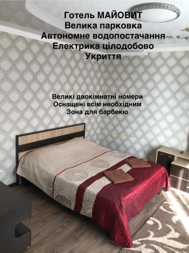 a bedroom with a bed and a poster on the wall at Готель МАЙОВИТ in Khmelʼnytsʼkyy