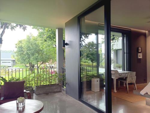 a glass door leading to a patio with a table at Chombua MaeWang ชมบัว in Chiang Mai