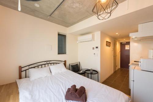 a bedroom with a bed with a pair of shoes on it at Fare Metallo Tokyo Nakano 11-room Hotel in Tokyo