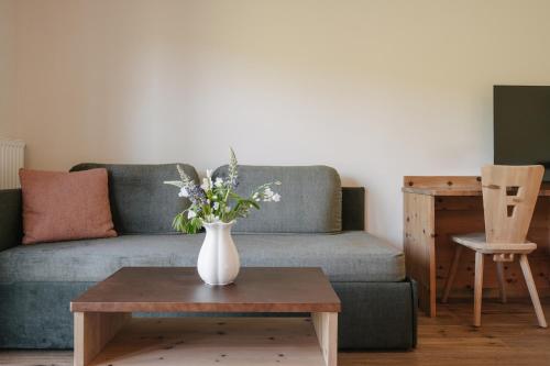 a vase of flowers on a coffee table in a living room at Brunelle Seiser Alm Lodge in Alpe di Siusi