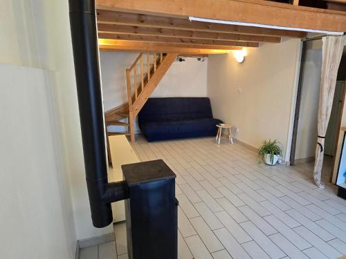 a living room with a staircase and a blue couch at La Pause Savoyarde in Ruffieux